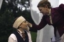 A woman touches the head of another person with a headband.
