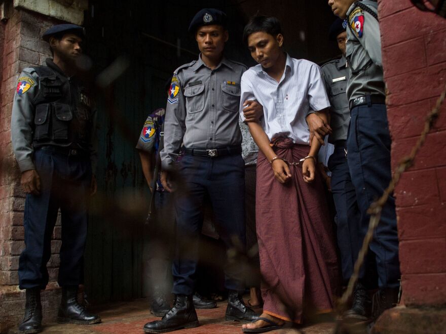 Kyaw Soe Oo, 28, leaves the Yangon courthouse in May, handcuffed and flanked by police officers.