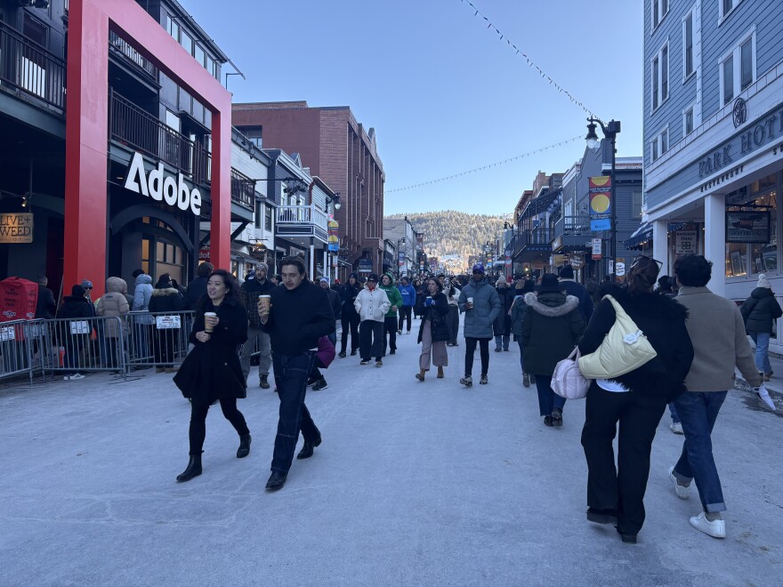 People walk down a busy street in Park City, Utah.