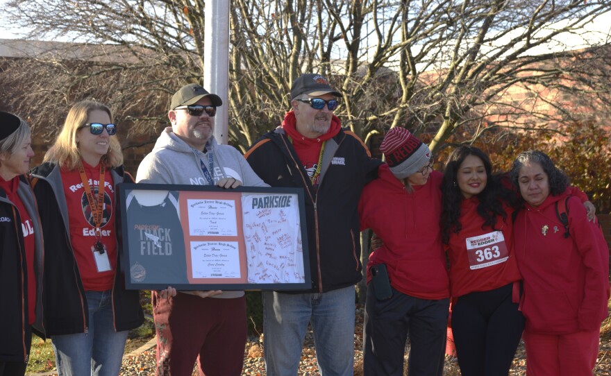 Members of Parkside Junior High School staff present a framed memento to Edder Diaz's family on Saturday, Nov. 22, 2025, near the PJHS flagpole after a Gift of Hope flag-raising ceremony, honoring Edder as an organ donor. He died Nov. 8, after a house fire earlier that week. His mother Adriana Garcia Lopez, stands right, and his sister Nicky Olivares, is second from right.