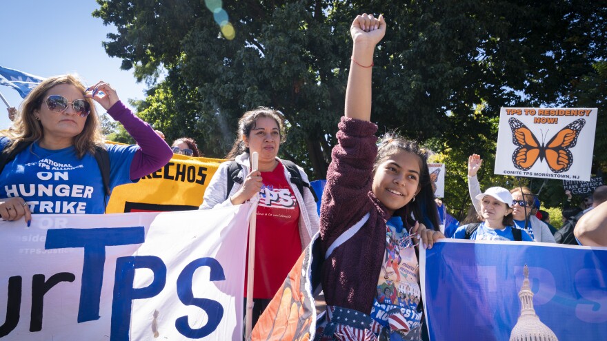 Marilyn Miranda, 12, of Washington raises her hand up during a protest for an extension of the Temporary Protected Status in September 2022 in Washington, D.C.