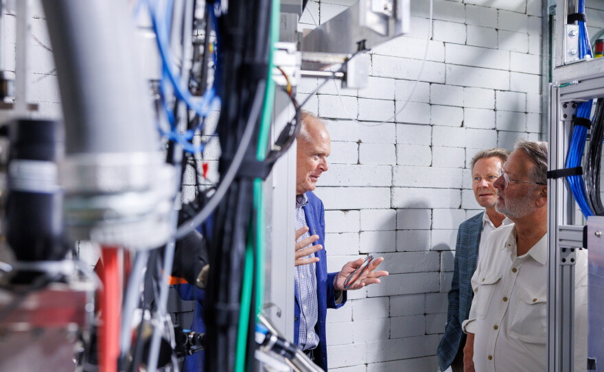 U.S. Sen. Gary Peters, right, visits the Facility for Rare Isotope Beams in East Lansing, Mich., on Aug. 28, 2026. He is joined on the tour by Michigan State University President Kevin Guskiewicz, center, and FRIB Laboratory Director Thomas Glasmacher, left. The visit was the last stop on Peters' final motorcycle tour of Michigan as senator.