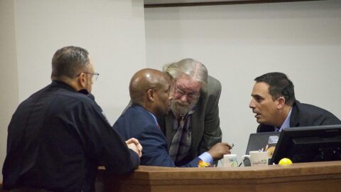 A huddle between North Port Police Department Chef Todd Garrison, City Manager Jerome Fletcher, Mayor Pete Emrich, and City Attorney Michael Fuino during a raucous meeting on data centers.