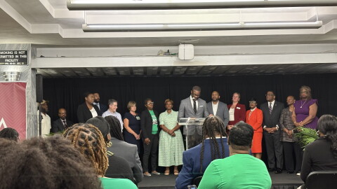 A crowd sits facing Birmingham Mayor Randall Woodfin and other city leaders at a press conference unveiling the city's 5-year strategic plan to reduce violence.