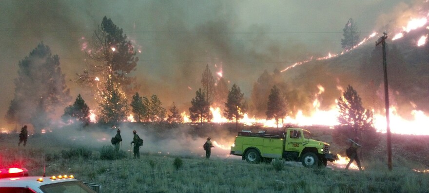 A U.S. Forest Service photo shows firefighters near the perimeter of the Elk Complex fire near Pine, Idaho, last summer. Lawmakers are calling for a change in the way America pays for wildfire disasters.