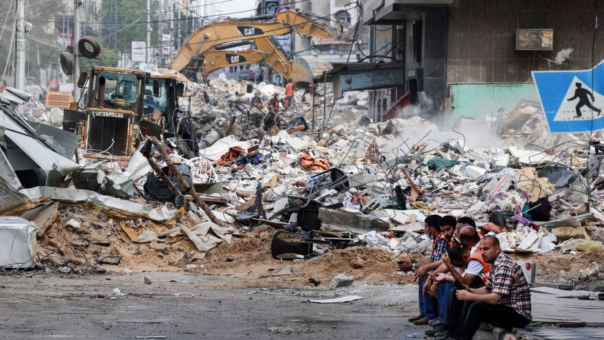 An excavator clears the rubble of a destroyed building in Gaza City on Sunday, following Israeli airstrikes.