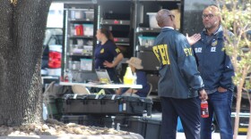 FBI and ICE officials speak outside of the Immigration Enforcement and Removal Operations office.