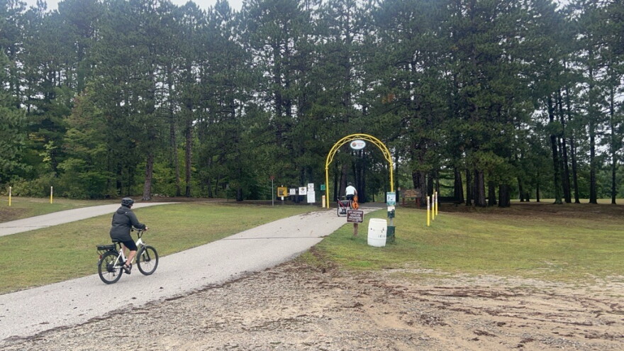 A family bikes through the entrance of the Mesabi Trail in Grand Rapids.