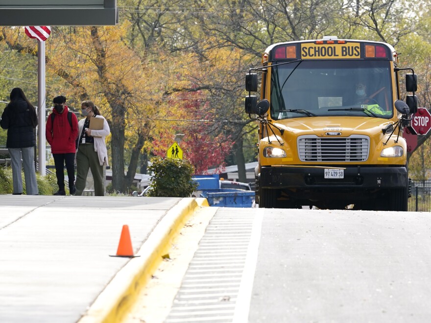 Students wear mask as they arrive their school for in- person learning at Holmes Middle School in Wheeling, Ill., Wednesday, Oct. 21, 2020. The Lake County Health Department recommended that all public and private schools in the county currently education children in the classroom immediately return to virtual learning because of the threats posed by the coronavirus pandemic. (AP Photo/Nam Y. Huh)