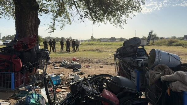 State troopers stand in the vacant, state-owned field by the Norman Food and Shelter as workers clear away the encampment as part of the governor’s Operation SAFE. With nowhere else to go, those camping in the field moved their belongings to the adjacent sidewalk.