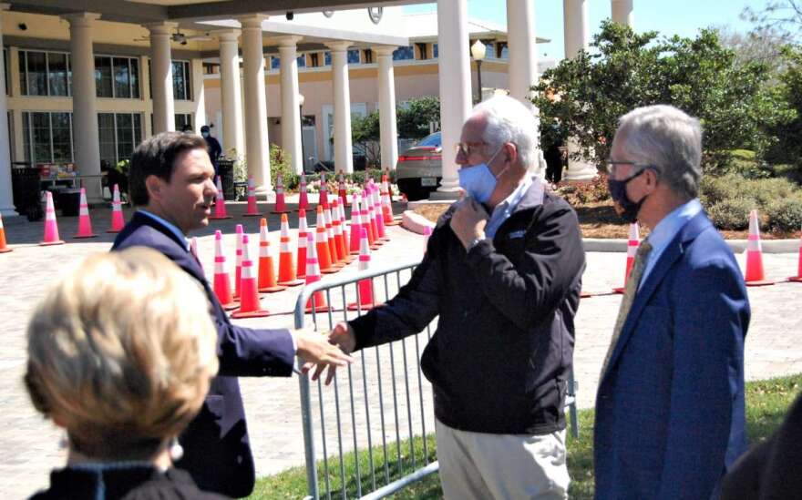 Florida Gov. Ron DeSantis greets Ocala Mayor Kent Guinn, center, and On Top of the World Communities President Ken Colen at a vaccination event at OTOW on Friday. Photo: Joe Byrnes