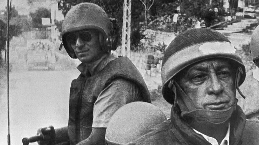 Israeli Defense Minister Ariel Sharon (right), in combat helmet and flak jacket, rides with his troops on June 15, 1982, as they head deeper into Lebanon. The Israelis drove Arafat and his Palestine Liberation Organization out of Lebanon, but Sharon was later found "indirectly responsible" for the killings of hundreds of Palestinian civilians carried out by a Lebanese militia allied with Israel.