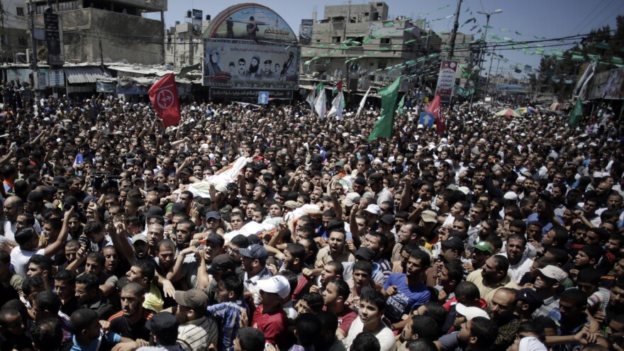 Palestinian mourners carry the body of three senior commanders of the Hamas military wing in the southern Gaza Strip on Thursday, after they were killed in an Israeli airstrike. Hamas executed more than a dozen people it says were spying for Israel.