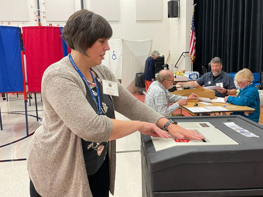 Portsmouth Ward 4 clerk Sarah LaChance feeds a ballot into the Accu-vote machine.