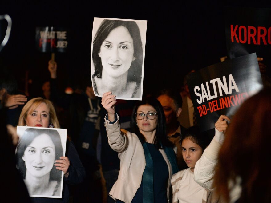 Protesters hold up pictures of Daphne Caruana Galizia as they gather earlier this month outside the prime minister's office in Valletta, Malta. Painful questions about the investigative journalist's murder have lingered since she was killed by a car bomb in 2017.