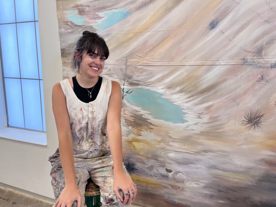 Artist Mahin Thorp sits in front of a work in progress