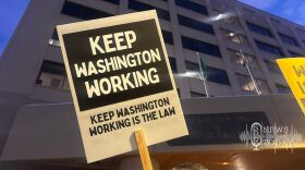 A rally attendee holds a sign in support of the 2019 Keep Washington Working Act, which prevents local police from collaborating with Immigrations and Customs Enforcement, a protest outside Spokane City Hall in 2025. A new report from University of Washington shows other immigration agencies have still accessed state data despite the law.