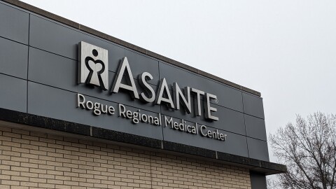 A metal sign on the corner of a building outside that reads, "Asante Rogue Regional Medical Center"