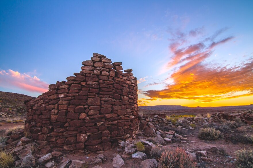 A photo of a stone tower in front of a  sunset. 