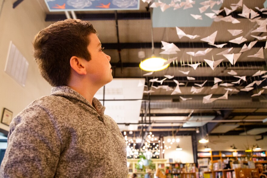 Ben Looper poses for a portrait in front of his art instillation, “The Butterfly Project,” at Lark & Owl Booksellers in Georgetown on Dec. 11, 2022. Ben and his mother created the art instillation to commemorate the individuals in the city of Georgetown who died from COVID-19.