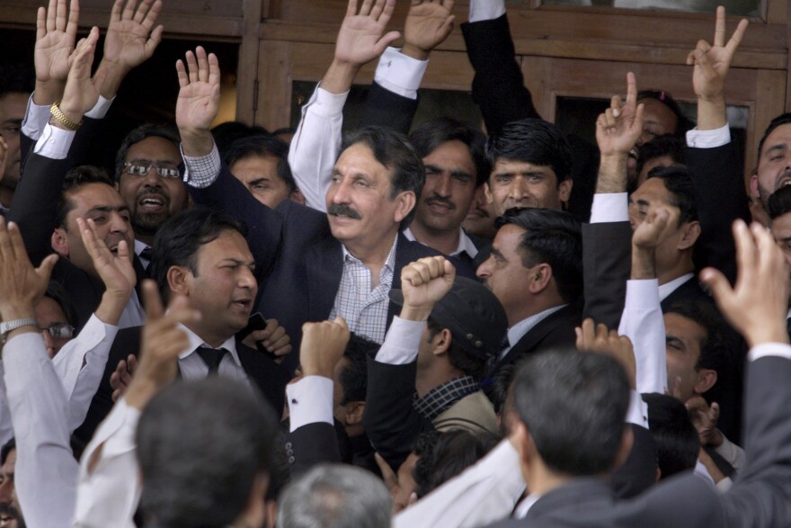 Chief Justice Iftikhar Chaudhry (center) is greeted by lawyers in Islamabad after the government announced it would reinstate him, in March 2009. Pakistan's longest-serving chief justice challenged the status quo and fought to chart a more assertive and independent course for the country's judiciary.