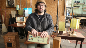Richmond artist Will Mullany sits in his studio holding the Generator Organ, one of several synthesizers he's created which mix found mediums and analog noise generators.