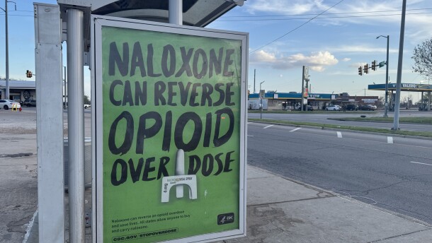 A sign about naloxone, an overdose-reversing medication, hangs on the side of a bus stop in Oklahoma City.
