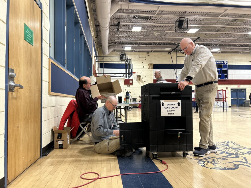Robert Clay stands over a ballot counting machine in Plymouth.