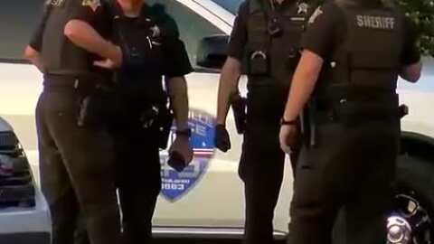 Evansville Police officers and Vanderburgh County deputies confer at the scene of a fatal shooting outside the AMC Theater off Pearl Drive, April 14, 2026