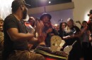 A man plays an instrument in a crowd.