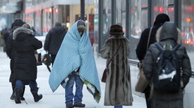 A homeless man who did not give his name bundles up in blankets in downtown Chicago during a deep freeze. (Kiichiro Sato/AP)