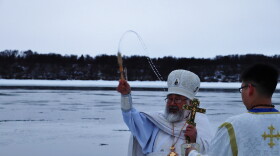 Archpriest David Askoak sprinkles the small crowd with blessed water at Theophany. Jan. 19, 2023.