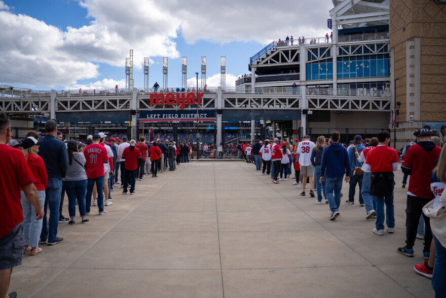 Two lines gather outside a stadium.
