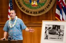 Hawaiʻi State Archivist Adam Jansen unveils a photograph of Hawaiʻi delegates bringing lei to the 1965 Selma-to-Montgomery march during the opening of a Martin Luther King Jr. photo exhibit at the Hawaiʻi State Capitol, Tuesday, June 30, 2026, in Honolulu.