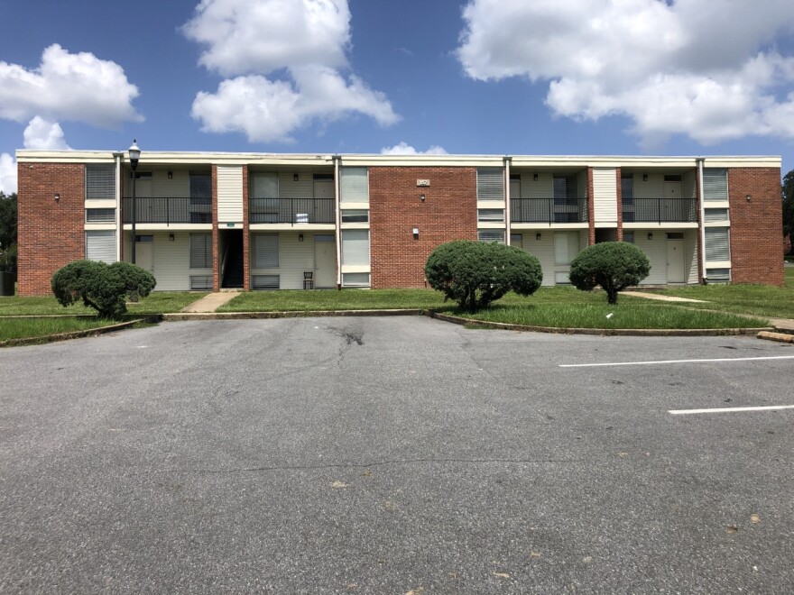 A quad-style apartment unit with a brick facade