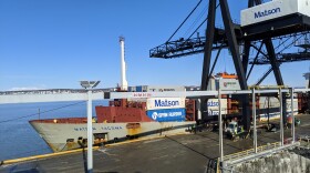 A crane lifts a conex