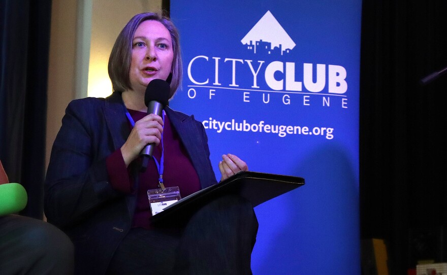 Person speaks into a microphone on stage.