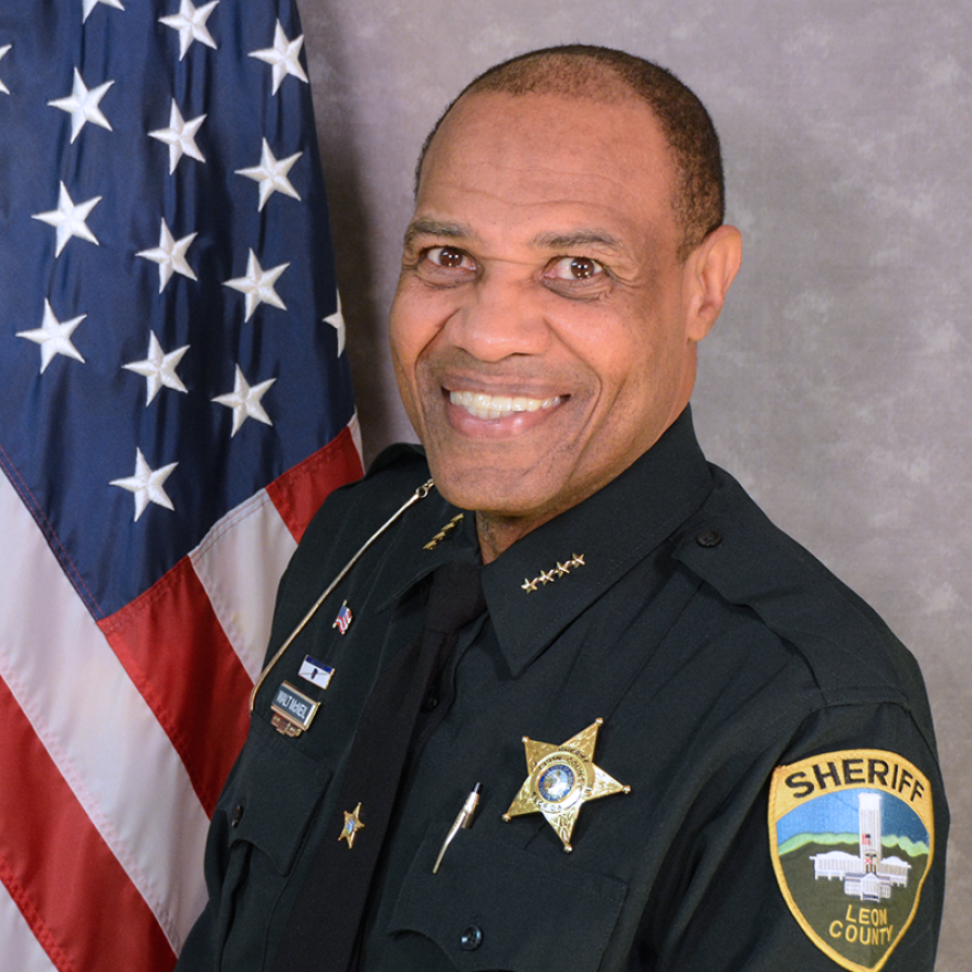 Man smiling in a sheriff's uniform.