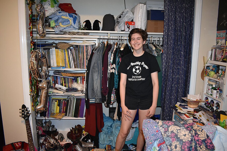 Claude Stikeleather poses in front of their closet.