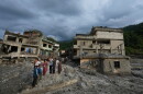 Residents and others look at damaged structures after flash flooding in the Devighat area of the Nuwakot district in Nepal, Friday, Aug. 28, 2026. (AP Photo/Rajesh Kumar Singh)