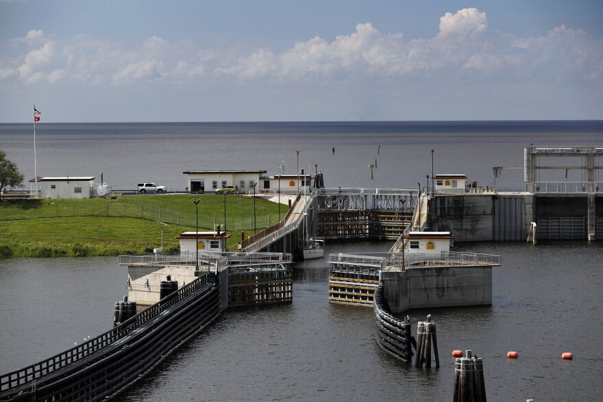 FILE: In this Friday, Oct. 25, 2019, 2019 photo, the doors of a lock open at Port Mayocca, Fla., allowing a sailboat to enter he St. Lucie Canal after leaving Lake Okeechobee, background. The lock and dam was built in 1977 to raise the water level in the lake and provide flood control.