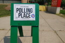 vote here and polling place signs line a street in Ann Arbor, Michigan