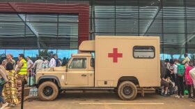 French soldiers stand near an army ambulance as citizens of European countries are seen queuing outside the Diori Hamani International Airport in Niamey.