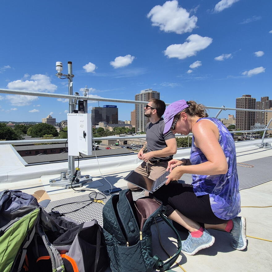 Researchers at SUNY ESF examine an air quality monitor in Syracuse.