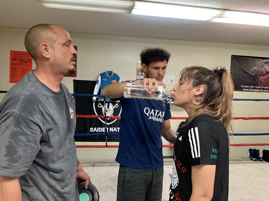 Training is a family affair. Trejo’s brother, Diego, gives her water between mitt drills with their father.