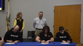 Kent Greenwell (back, center) of Caterpillar-Pontiac was one of six McLean County business partners at Heartland's signing ceremony.