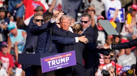 Republican presidential candidate former President Donald Trump is surrounded by U.S. Secret Service agents after being shot at during a campaign event in Butler, Pa., Saturday, July 13, 2024.