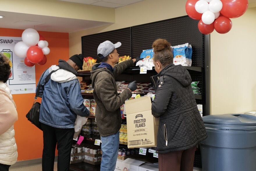 Workers restock shelves at the Community Feed at Berkley.