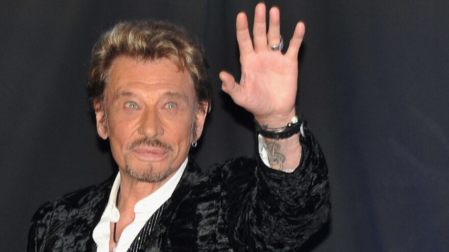 Johnny Hallyday waves to his fans during his album launch celebration in Paris in 2011.