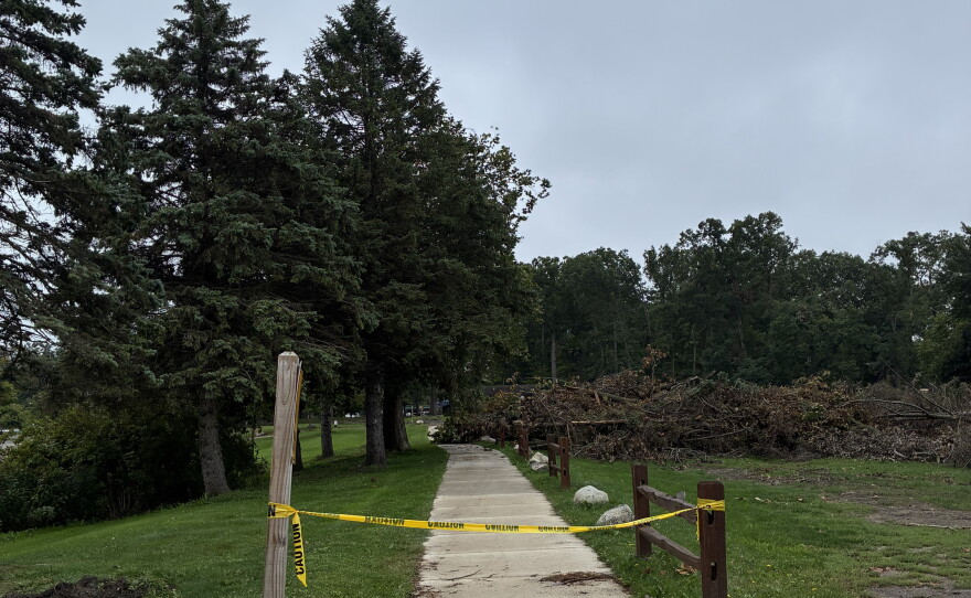 Caution tape marking off a part of a sidewalk in a park
